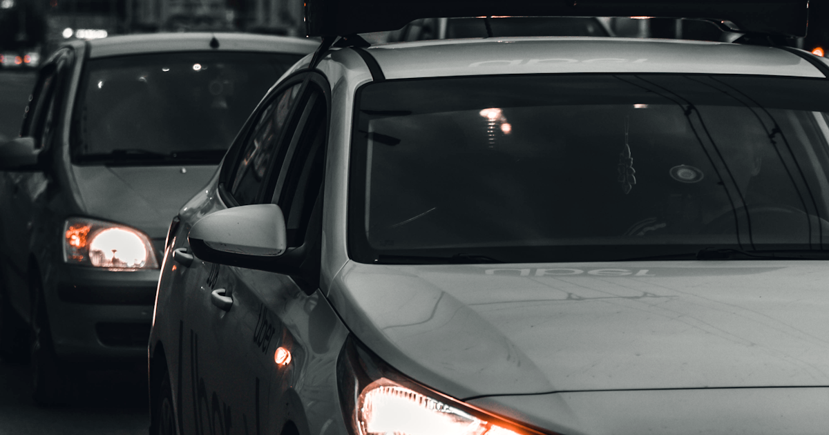 Rideshare driver checking smartphone app while waiting in vehicle