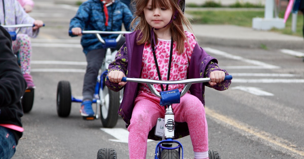Young child wearing a helmet learning to ride safely