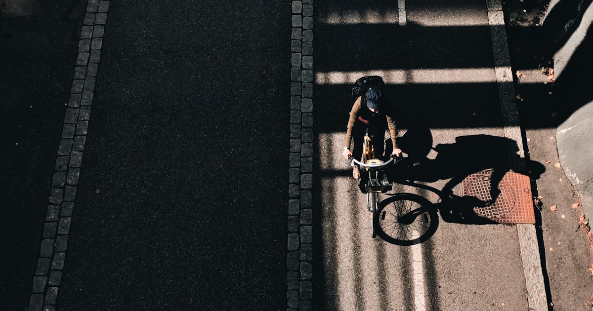 Bicycle parked near a wet city intersection under fading daylight