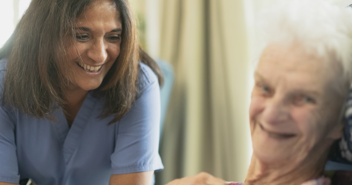 A quiet, understaffed nursing home room with an empty chair by a window