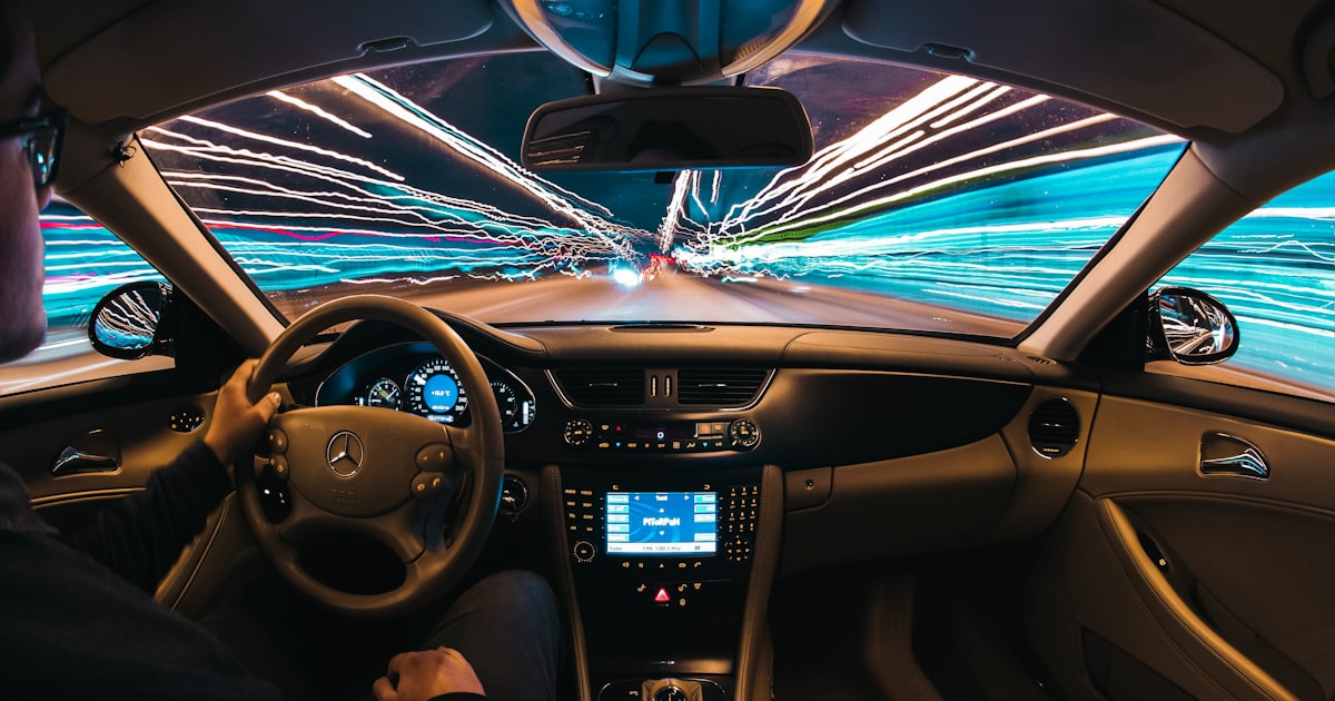 A driver keeping hands near the wheel while a car runs a driver-assistance system on an Ohio highway