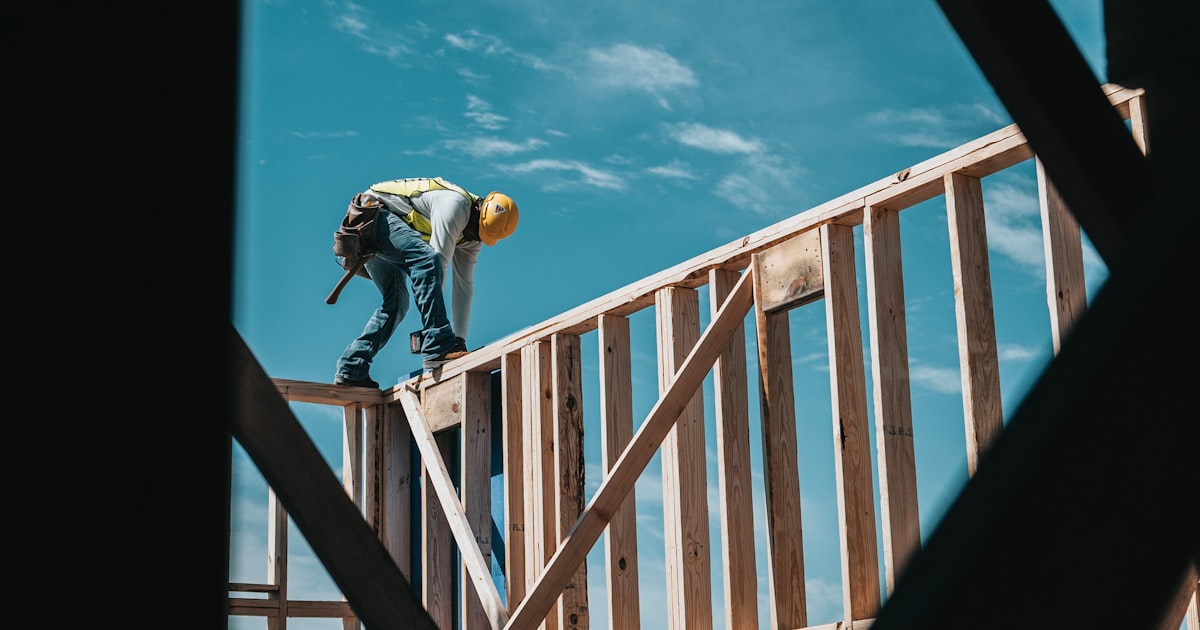 Worker in a hard hat and safety harness on scaffolding at a Northeast Ohio construction site