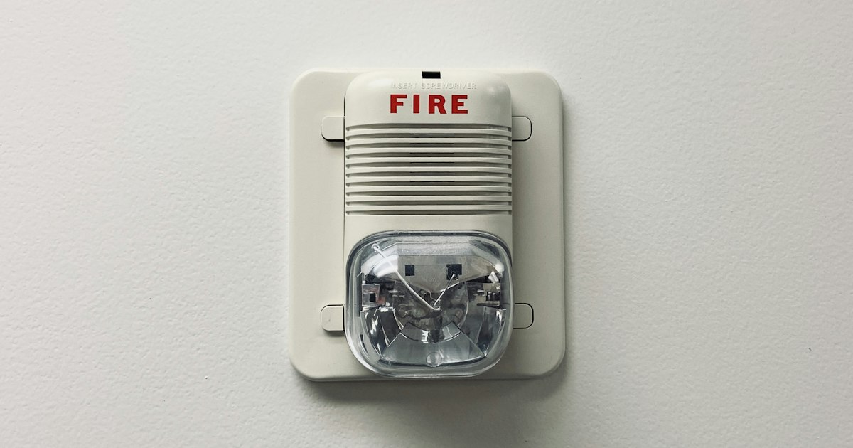 A home smoke alarm mounted on a ceiling, a key defense against heating fires