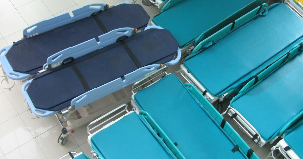 A patient on a stretcher in a hospital emergency room being evaluated by staff