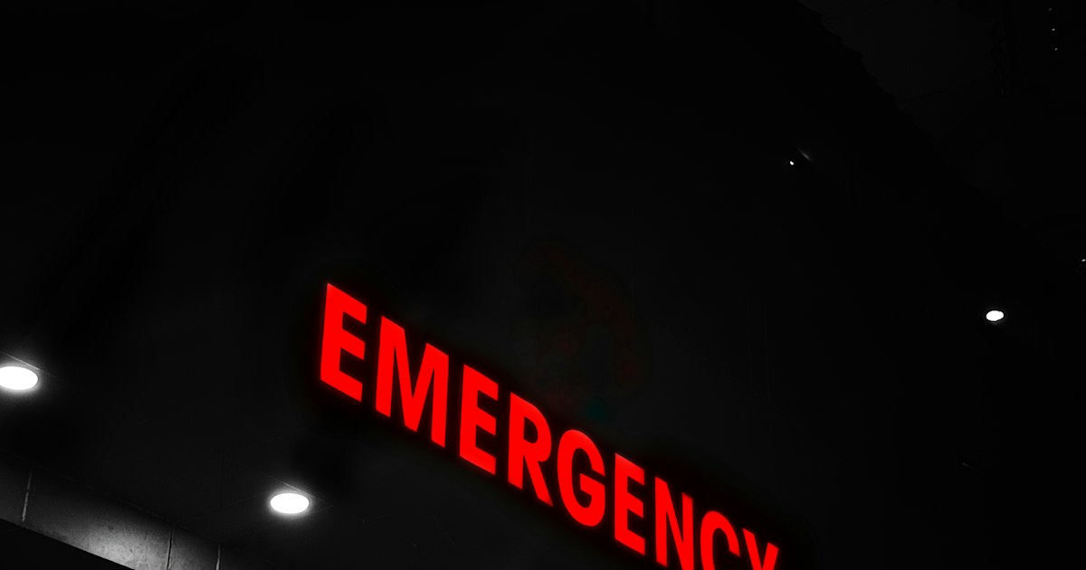 A busy hospital emergency department corridor with medical staff and equipment