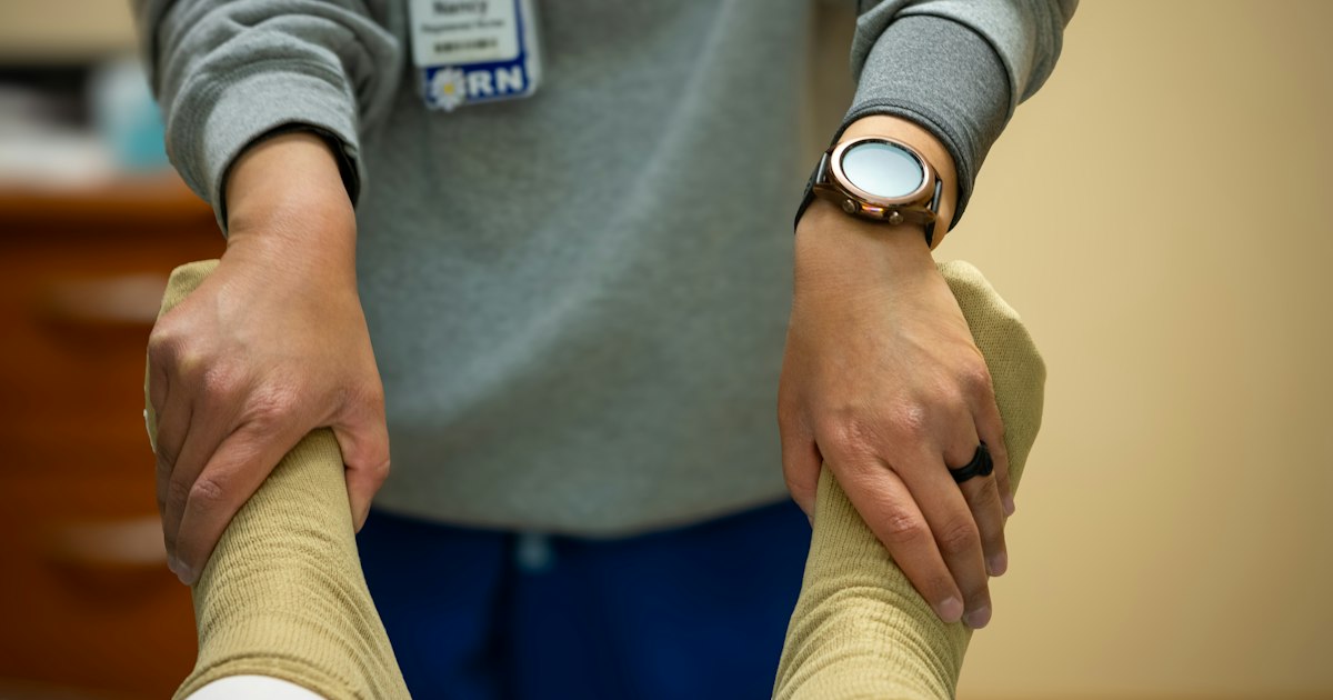 A nurse guides a patient through physical therapy during spinal cord injury rehabilitation